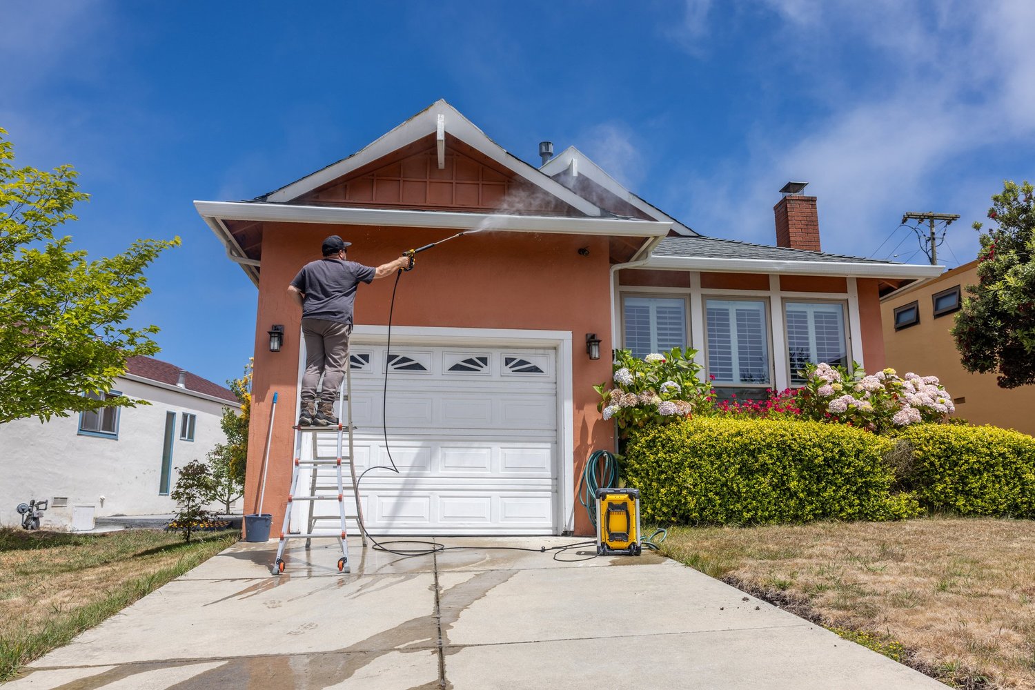 Pressure washing house exterior and driveway